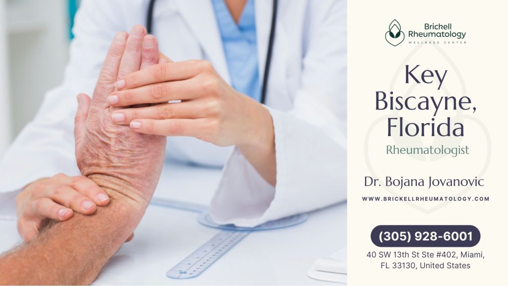 An elderly patient receives a hand examination from a doctor in a Key Biscayne rheumatology office.