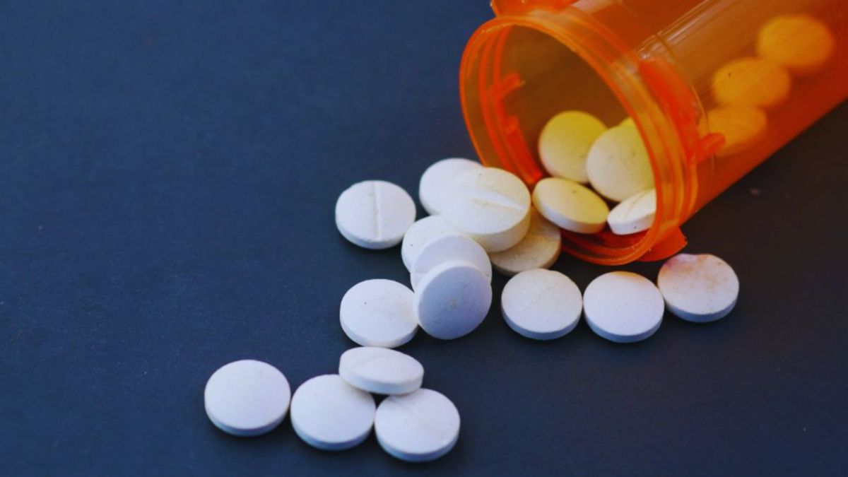 Orange prescription bottle spilling corticosteroid pills, illustrating medication use and health management.