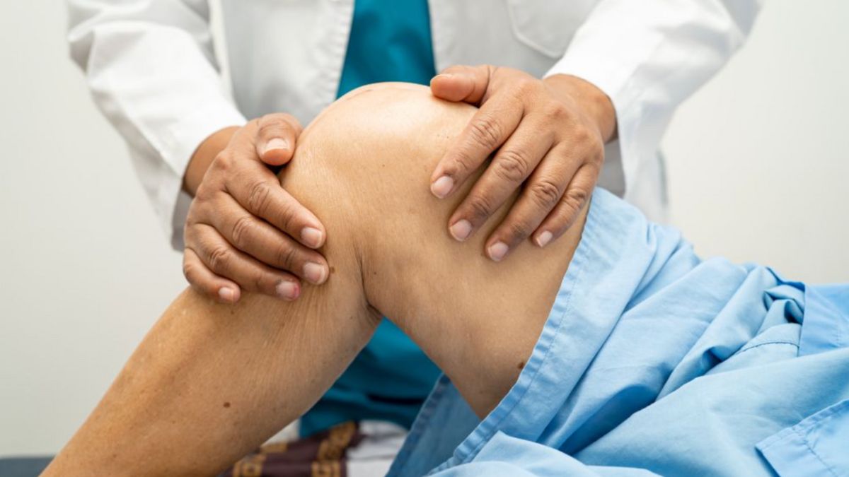 A healthcare professional examines a patient’s knee, highlighting a personalized and hands-on approach to rheumatoid arthritis care through functional medicine.